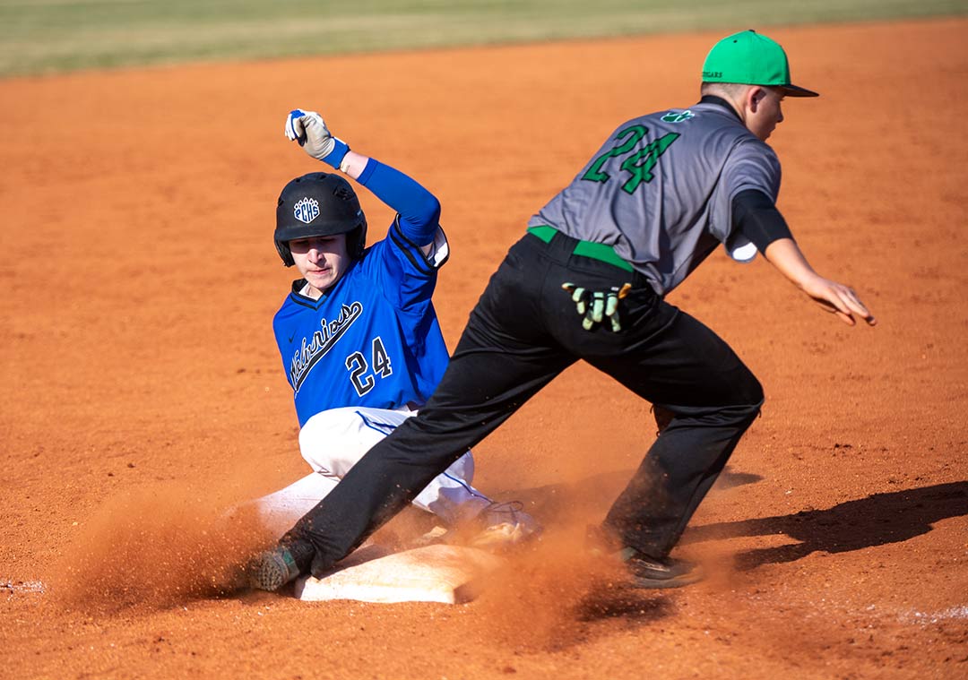 Polk County's Matthew Foy slides into third after advancing on a wild pitch during the second inning of Tuesday's game